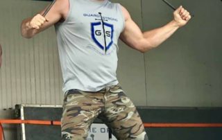 Nitro bending a steel bar over his head.